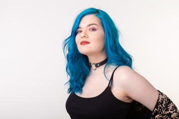 Fototapeta premium People and fashion concept - Young woman with choker and blue hair posing over white background