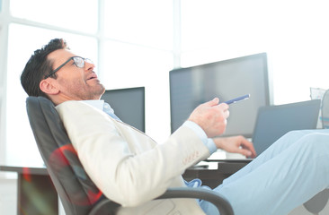 Naklejka na ściany i meble businessman sitting at his Desk during a working break