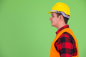 Profile view of happy young multi ethnic man construction worker smiling