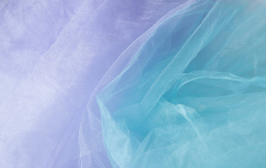 Obraz premium Textile and textural concept - close up of crumpled lilac veil and turquoise wavy fabric background with copy space for text or image. Top view. Flat lay. Fabric pattern.