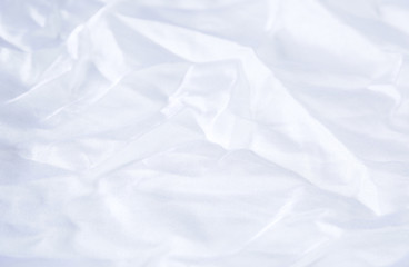 Textile and textural concept - close up of crumpled white silk wavy fabric background with copy space for text or image