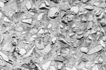 Stone rubble in a concrete wall painted with silver paint as a background