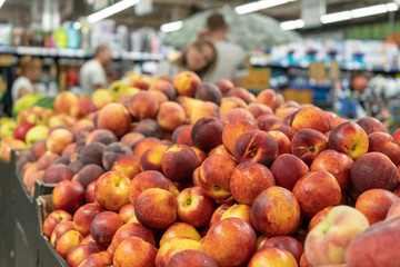 Fresh, ripe, juicy nectarines on the store counter in front of fruits