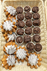Freshly baked biscuit vanilla and chocolate muffins in a wicker basket in the supermarket’s window waiting for the buyer
