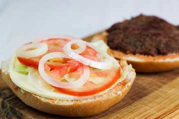 Ground beef burger with tomato, onion and lettuce, homemade.