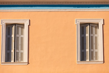 Old window shutters on orange home