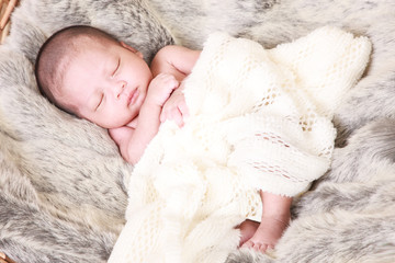 Adorable asian newborn baby in wrap sleeping on white blanket background. Portrait of newborn boy sleep on bed. open eyes.