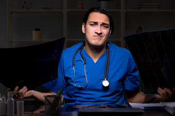 Young male doctor in the hospital at night 