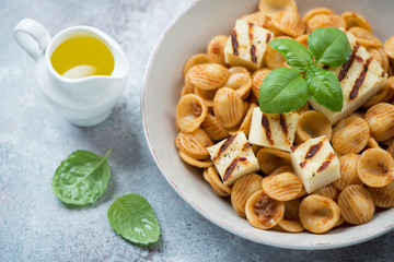 Orecchiette with sun dried tomato pesto, slices of grilled cheese, olive oil and green basil,...