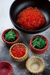 Bowl of red caviar and vegetable tartlets with chuka salad and caviar, closeup