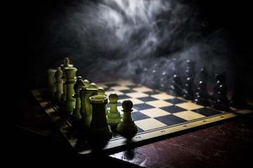 Chess board game concept of business ideas and competition. Chess figures on a dark background with...