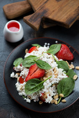 Salad with strawberry, baby spinach, cottage cheese and peanuts, studio shot