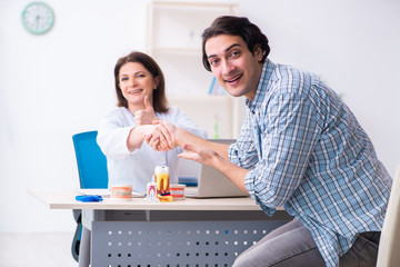 Young man visiting female doctor stomatologist