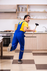 Young male contractor repairing tap at home 