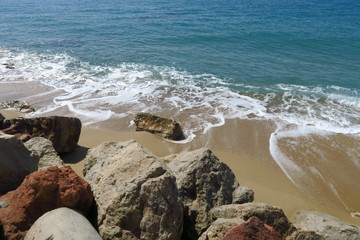 Rochers ocres dans l'eau de la mer avec vagues.