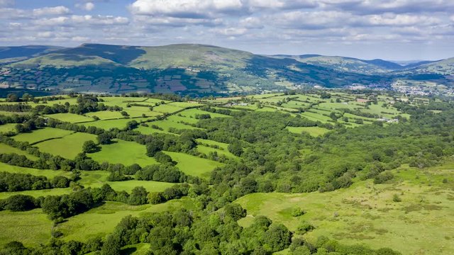 Aerial hyperlapse of clouds and shadows moving across a rural, farming landscape (Crickhowell, Wales)