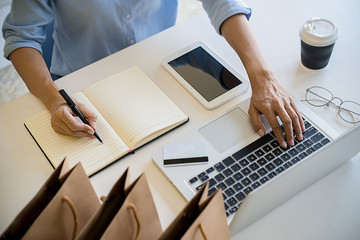 Young woman holding credit card and using laptop computer. Online shopping concept