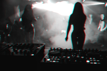 silhouette girls dancers on stage in nightclub on background music the mixer DJ