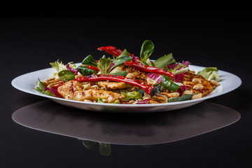 Mexican salad with hot pepper chiken fillet lettuce on plate