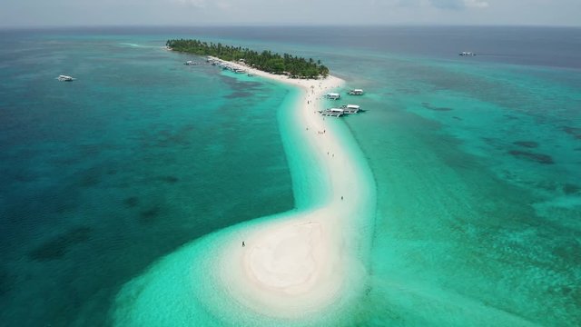 Aerial view flying over a beautiful sandy beach and traditional Bangka boats (Kalanggaman Island)