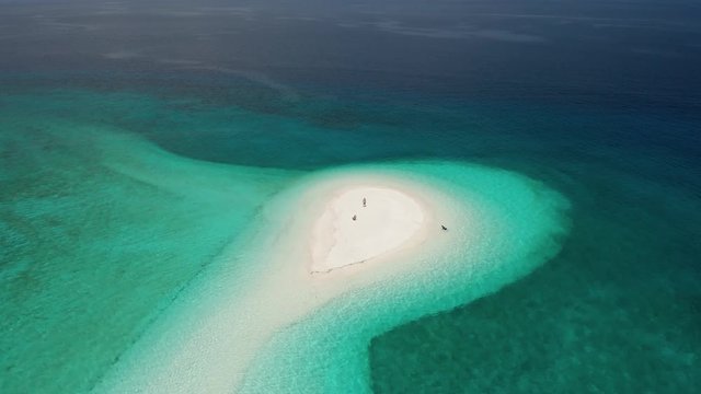 Aerial drone view orbiting a beautiful sand spit on a remote tropical island