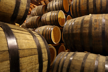 Rows of alcohol barrels in stock. Distillery. Cognac, whiskey, wine, brandy. Alcohol in barrels