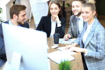 Group of business partners discussing strategies at meeting in office.