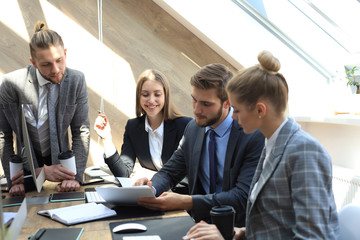 Business partners discussing documents and ideas at meeting.
