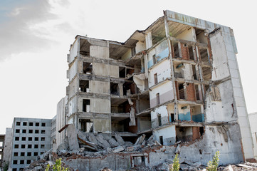 The remains of a destroyed concrete building against the sky. Background