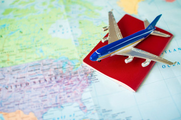 Fototapeta na wymiar toy aircraft and neutral passport on the world map. travel and air transportation concept, flight to north america, trip by plane, booking flights
