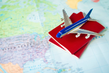 Fototapeta na wymiar toy aircraft and two neutral passports on the world map. travel and air transportation concept, flight to north america, trip by plane, booking flights