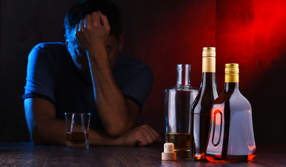 Bottles with alcoholic beverages and the figure of a drunk man