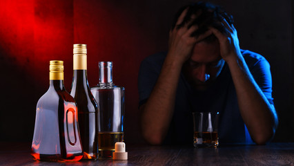 Bottles with alcoholic beverages and the figure of a drunk man
