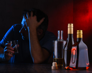 Bottles with alcoholic beverages and the figure of a drunk man