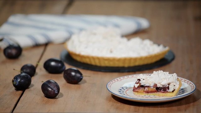 Delicious sliced cake of ripe plums close-up on the table.