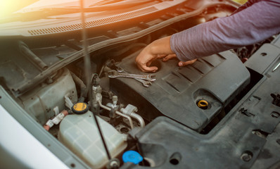 A hand technician checking or fixing the engine of a modern car. mechanic performing maintenance and car maintenance. charge the battery in the cold