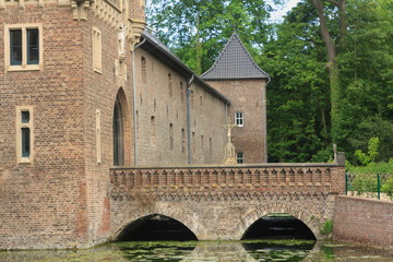 Fototapeta na wymiar Moated castle with an old bridge