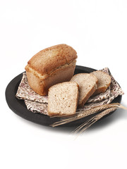 food photography of a loaf of sliced ​​rye bread with three pieces on a cloth towel side view on a dark wooden plate on a white background isolated close up