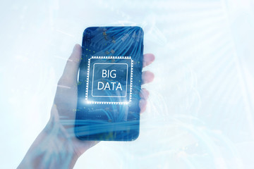 Woman Hand holding mobile phone. Server room background. Inscription on a virtual screen: Big Data. Double exposure.