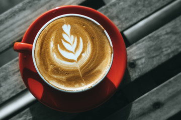 Top view cup of hot coffee or cappuccino is placed on an outdoor wooden table in the morning. Warm festival with warm drinks in the winter.