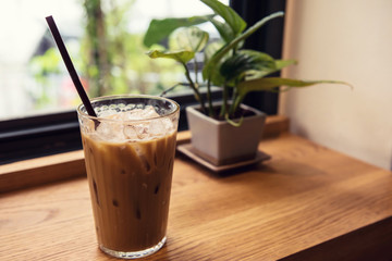 Ice coffee on wood table near window
