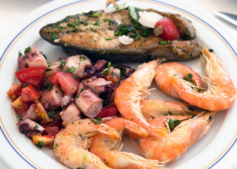 Shrimp, fish and octopus salad on a plate in a cafe