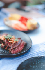 delicious medium rare grilled beef cut on black dish, restaurant decorated style for bbq menu design