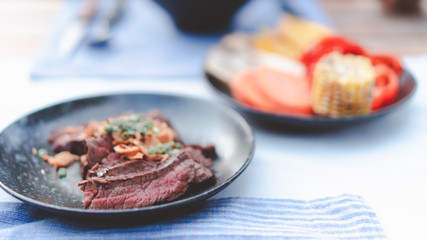 delicious medium rare grilled beef cut on black dish, restaurant decorated style for bbq menu design