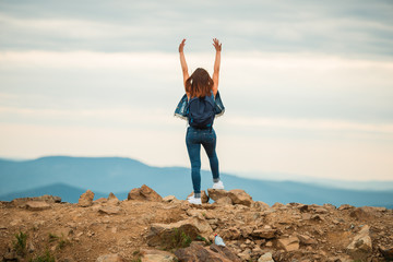 A healthy woman celebrates during a beautiful sunset. Happy and free. stand on the edge of the mountain. beautiful mountain.