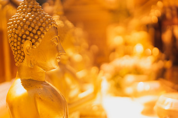 golden buddha statue whith blurred golden pagoda background, selective focus, buddhist holy day concept - obrazy, fototapety, plakaty