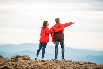 Young couple looks in the same direction, into the distance. Rear view. Loving couple. a romantic couple in love stands together on a mountain. silhouettes of a young man and a woman on vacation.