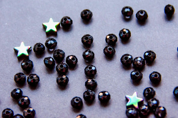 Colorful, black beads and stones isolated on white and grey background