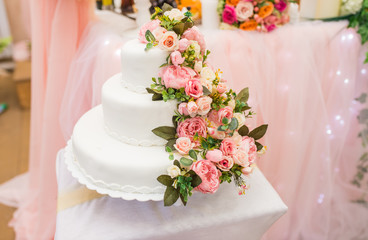 the bride and groom cut the beautiful white wedding cake with fresh flowers