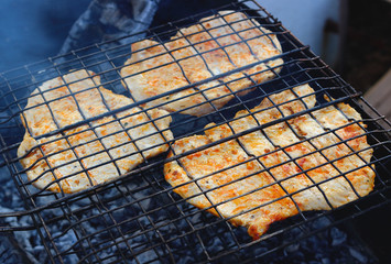 BBQ pork entrecote cooking in smoke on grill. Concept background for a family summer picnic or dinner outdoor. Selective focus, top view.
